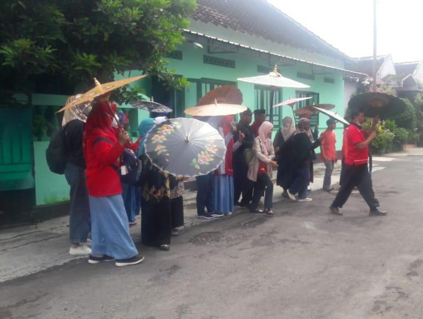 WISATAWAN BERKUNJUNG KE RUMAH PAYUNG MELIHAT PROSES MEMBUAT PAYUNG DAN FOTO SELFI.